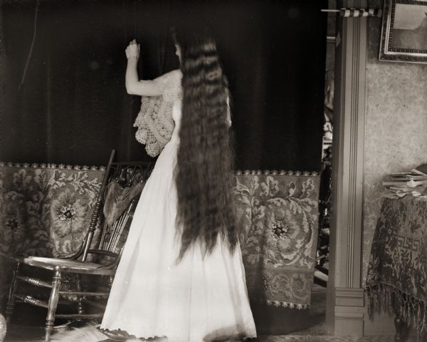 Edward Bass' wife, Ada, standing with her back to the camera. Her hair reaches to her knees..