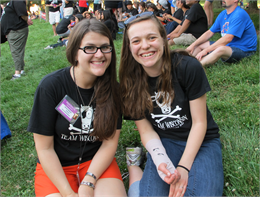 Student and coordinator sit on grass