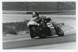Crouched 250 rider leans his bike, knee low, at Turn 5 during the 1980 races at Road America