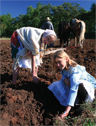 Two girls help work in the fields.