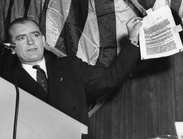 Senator Joseph R. McCarthy of Wisconsin holding up a report on Democratic Presidential candidate Adlai E. Stevenson that linked him to a host of extreme left-wingers, even Alger Hiss.