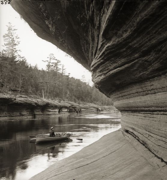 Pictured is a man in a rowboat at Berry's Landing, along the rocks opposite.