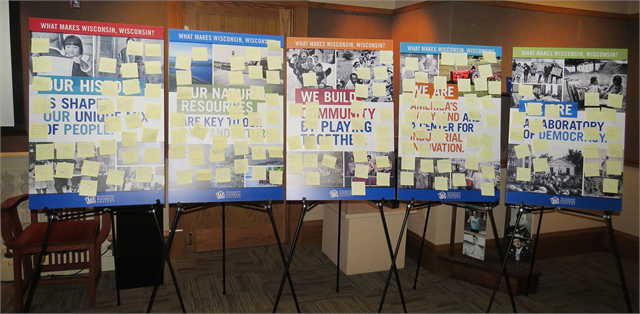 Post-It notes with suggestions from Janesville guests fill the "What Makes Wisconsin, Wisconsin?" theme boards.