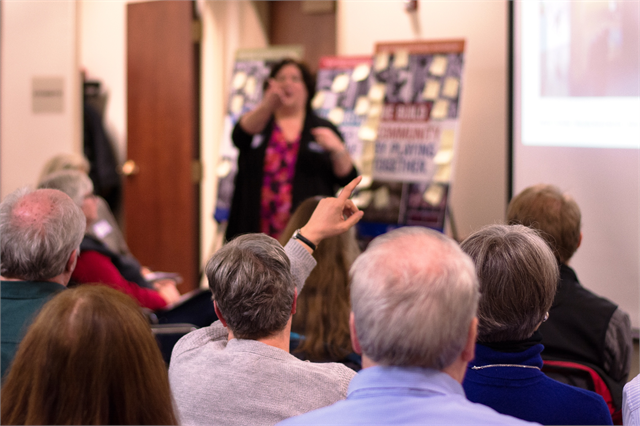 A guest raises his hand to share an idea as Wisconsin Historical Society Special Projects Director Alicia Goehring conducts a workshop activity during the Feb. 11, 2019 "Share Your Voice" new museum session in Mauston.