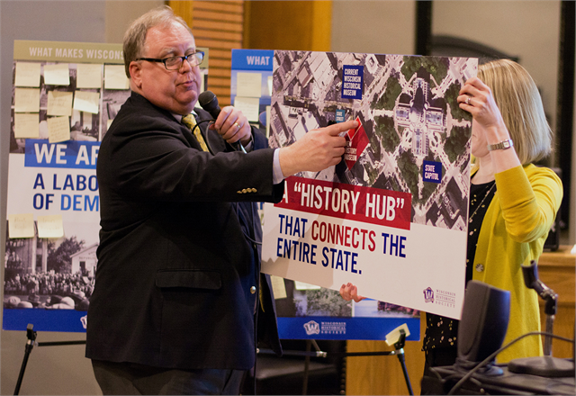 Society Director Christian Øverland shows guests where the new Wisconsin history museum will be located on the Capital Square in Madison, and how much larger it will be than the current Wisconsin Historical Museum.