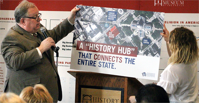 Wisconsin Historical Society Director Christian Øverland and staff member Katie Shapiro hold up a map of the Capitol Square in Madison, where the new, modern and much larger state history museum would replace the current Wisconsin Historical Museum.