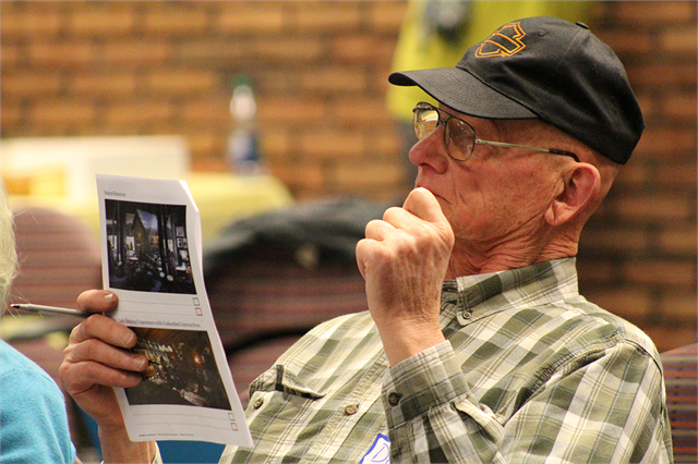 Don Kaus examines a booklet of concept exhibit design renderings during the Wisconsin Historical Society's "Share Your Voice" new museum listening session April 17, 2019 at the La Crosse Public Library.