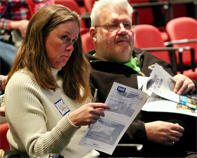 Leila Albert, left, and John Bates listen to a discussion about new museum early concept design renderings, which were provided in a packet at the "Share Your Voice" listening session on May 9, 2019 in Hudson.