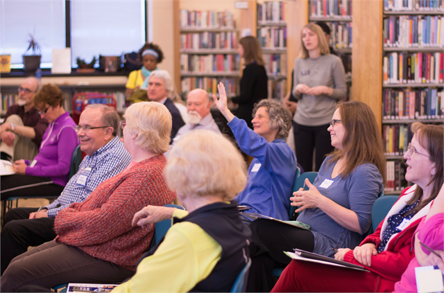 Holli Rosenberg raises her hand to share a comment at the Wisconsin Historical Society's "Share Your Voice" new museum listening session May 23, 2019 at the Racine Public Library.