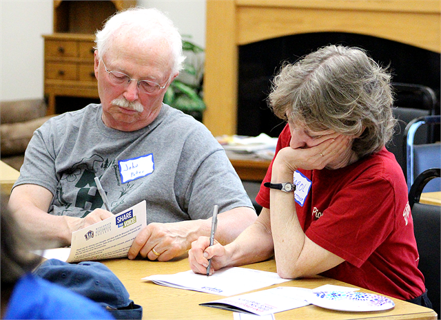 John Peter and Carol Kettner write their comments on a packet of concept exhibit design renderings for a new state history museum during the Wisconsin Historical Society's "Share Your Voice" listening session May 29, 2019 in Cameron.