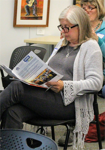 Sheree Peterson, Vice President of the Bayfield County Historical Society, reviews a packet of renderings of concept exhibit designs for a future Wisconsin history museum  during the Wisconsin Historical Society's listening session in Eagle River.