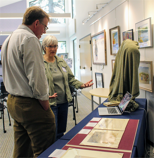 Carol Tews, left, of the Land O' Lakes Historical Society, and Matt Blessing, Director of the Wisconsin Historical Society's Library, Archives and Museum Collections, discuss rare artifacts from the Society's collections on display in Eagle River.