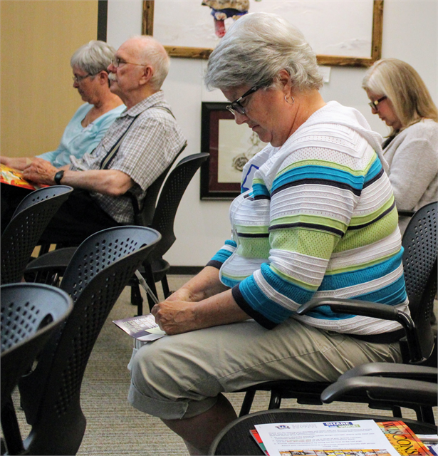 Lori Berryman, secretary of the Dr. Kate Museum in Woodruff, writes her comments on a packet of concept exhibit design renderings during the Wisconsin Historical Society's new museum listening session May 30, 2019 in Eagle River.