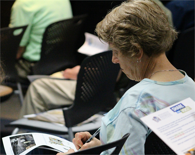 A woman writes down her thoughts about new museum concept exhibit renderings during the "Share Your Voice" session June 5, 2019 in Eau Claire.