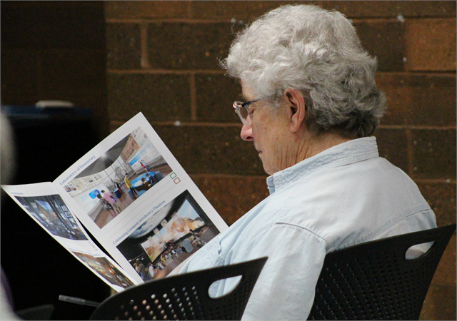 A guest examines a packet of new museum concept exhibit design renderings during the Wisconsin Historical Society's "Share Your Voice" listening session June 5, 2019 in Eau Claire.