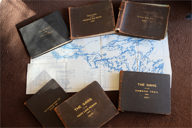 Photography journals created by Howard Greene, placed on a map of the boundary lakes.