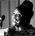 African American female political figure and civil rights activist Fannie Lou Hamer speaking into microphones.