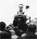 Lawrence Guyot, civil rights activist, stands and addresses a seated group.