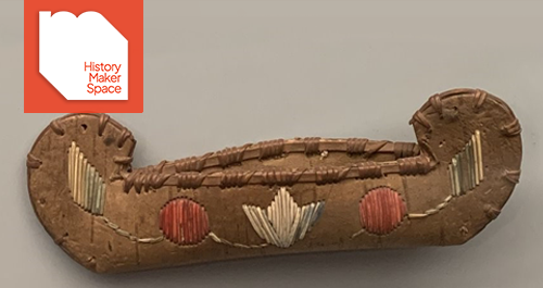 a toy canoe bound with string and embroidered with different colored string
