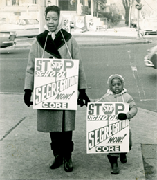 A woman and child carry CORE picket signs protesting school segregation. WHI 4993.