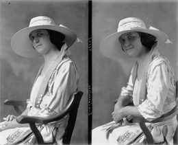 A girl sitting in a chair, shown from the waist up in two views, one reflective and one smiling. She is wearing a broad-brimmed hat and a white dress.