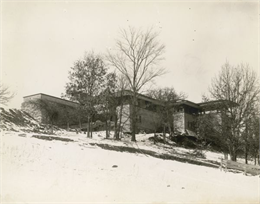 Southeast elevation of Taliesin in winter. Construction debris is scattered around the building base.