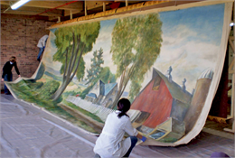 Conservators working on one 28 foot panel of the mural on an oversized easel.