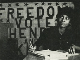Unidentified black woman seated at a table. Banner reads 'Freedom Vote / Henry and King.'