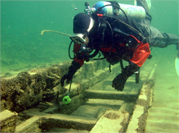 Scuba diver examining a sunken ship.