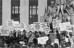 Crowd holding picket signs at an anti-Vietnam War rally in Pioneer Park in Minneapolis.