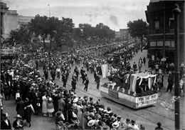Image of float and people marching and viewing a Labor Day parade in Madison, Wisconsin.