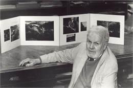 Paul Vanderbilt sitting in front of a display of his images and poetry.