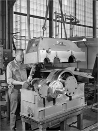 Ron Kudlewski, a Falk employee, attends to the test stand for large motors in the High Speed Department. This motor was later purchased and used by the Louis Allis Company. Falk caption reads, "5000 HP unit 1800/3600 rpm."