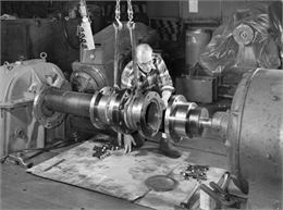 A male employee, Al Arndt, attends to a slide coupling. Falk caption reads, "Photos of a special slide coupling. Size 50GL32S... See Engineering File for exact specifications. Assembly drawing 424364."