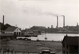 A view across Kenosha harbor at the large Simmons Company factory building.