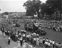 Ringling Brothers, Barnum and Bailey Circus float in Sauk County's Wisconsin Centennial Parade on street downtown with a large crowd in the street and park.