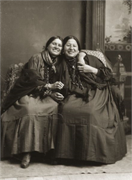 Portrait of two smiling Ho-Chunk (Winnebago) women identified as Clara St. Cyr, a Nebraska Winnebago, left, and Lucy Davis (NukZeeKah), the sister of John Davis.