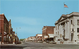 Color postcard of downtown Antigo, at the intersection of 5th Avenue and Superior Street looking north.