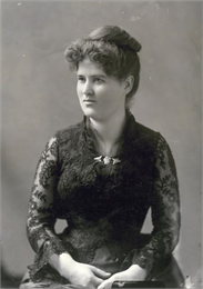 Formal studio portrait of Belle Case La Follette wearing a black lace dress.