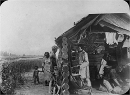 A diorama depicting several people, including a small child, gather at a fur trading post in Juneau, Alaska.