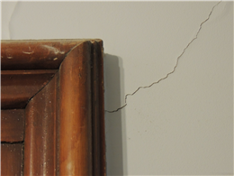 A diagonal plaster crack coming off the corner of an interior door, a sign the floor has sagged.