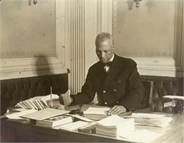 Samuel Pierce is seated at a desk in the executive offices of the Governor.