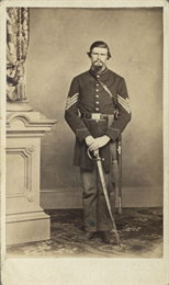 Full-length carte-de-visite portrait of First Sergeant William N. Williams from Company K of the 27th Wisconsin Infantry, standing in uniform holding his sword in front of him.