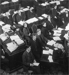 Detail of the Assembly Chamber photograph focusing on the journalists seated near the front of the room.