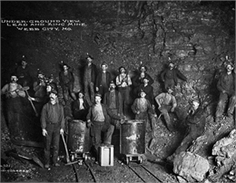 A photograph of men standing along the sides of a lead mine in Webb City, MO.