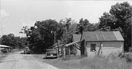 A central Wisconsin labor camp consisting of a row of wooden framed building with asphalt siding which housed migrant laborers.