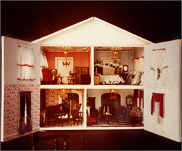 Interior of dollhouse with doors open, showcasing four rooms decorated with miniature furniture.