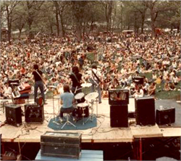 Butch Vig playing the drums at an outdoor concert with a large crowd at Olin Park.