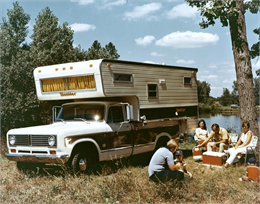 Color advertisement of a family camping near a lake with an International 1310 pickup truck and a Monitor camper.