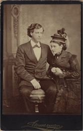 Nina Lynn Sturgis and Hercules Louis Dousman pose together in a studio in front of a painted backdrop.